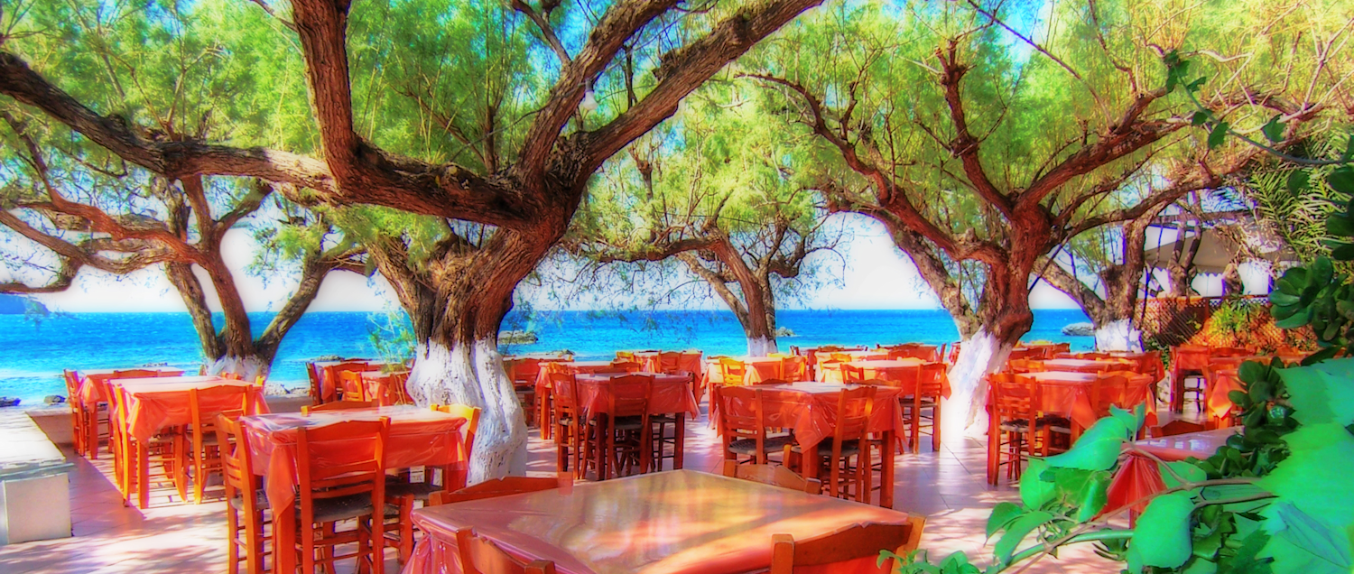 Tables at a Cretan taverna next to the sea